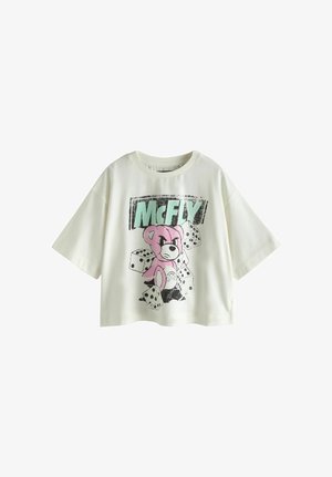 Tricou alb cu mâneci scurte, cu ursuleț roz de desene animate, zaruri negre și text mare „McFLY” verde și negru pe față.