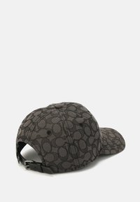Gorra de béisbol en negro y gris con una tela estampada, que presenta un cierre de correa ajustable y un borde curvado. Detalle de superficie texturizada visible.