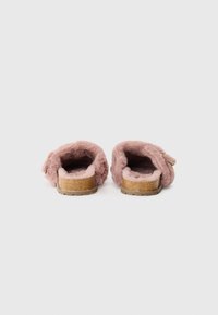 Chaussons en moumoute roses avec une texture douce, design à dos ouvert, semelle intérieure rembourrée et semelle semblable au liège. Aucun matériel ou motif proéminent.