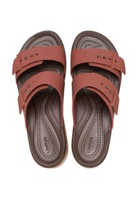 Pink rubber sandals with two adjustable straps and brass studs. Textured brown footbed with wave pattern and logo "LiteRide by Crocs."