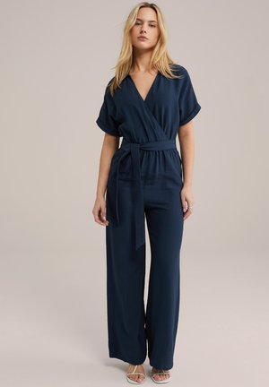 Marineblå jumpsuit med korte ærmer, svømmedesign og bælte i taljen. Letvægtsstof med en glat overflade. Bred ben silhuet.