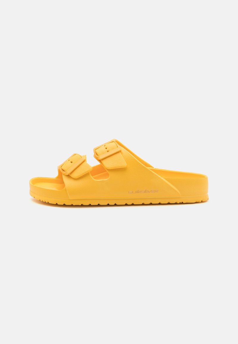 Sandale en caoutchouc jaune avec deux sangles à boucle réglables, semelle intérieure texturée et semelle extérieure striée pour une meilleure adhérence. Design simple et ouvert.