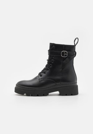 Schwarze Lederknöchelstiefel mit einer abgerundeten Spitze, Schnürung vorne, seitlichem Schnallen-Detail und einer strukturierten, dicken Sohle.