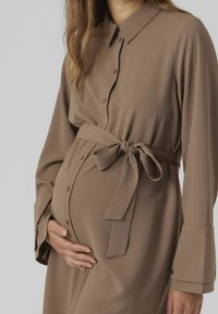 Lång, knäppt klänning i mjukt, beige jersey-tyg med en knytning i midjan och långa ärmar, med en klassisk krage och manschett detaljer.