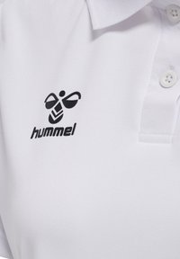Weißes Polohemd mit einem schwarzen, stilisierten Bienenlogo und dem Schriftzug "hummel" auf der linken Brust, mit Kragen und zwei weißen Knöpfen.