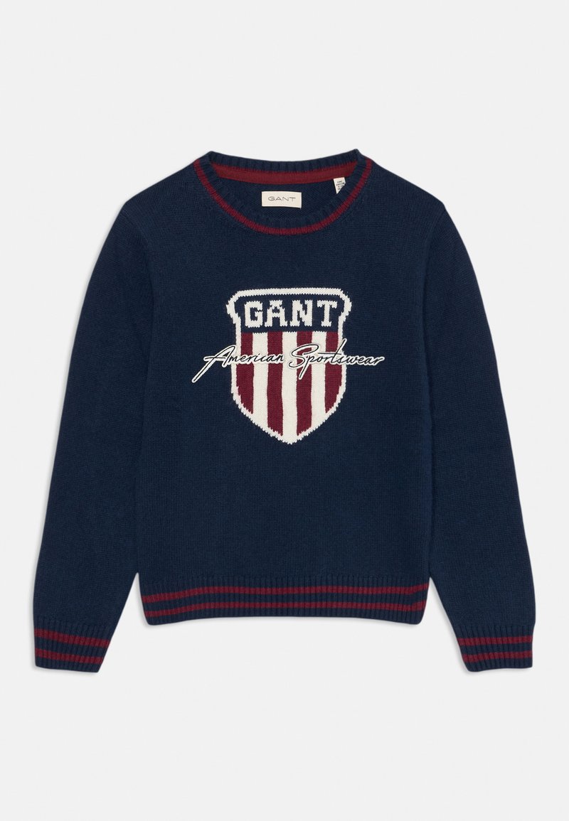 Maglione blu navy con logo a scudetto a righe rosse e bianche, testo "GANT American Sportswear" e polsini e orlo a coste a righe rosse.