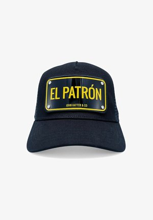 Svart keps med en böjd skärm, prydd med en gul rektangulär patch märkt "EL PATRÓN" i fet stil, accentuerad med två metallknappar.
