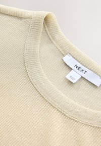Hellbeiges Strickoberteil mit rundem Ausschnitt, aus strukturiertem Stoff und mit dem Label "NEXT" am Halsausschnitt.
