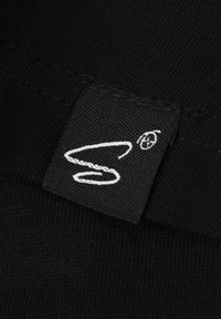 Etichetta in tessuto nero con logo e cuciture ricamate bianche. L'etichetta presenta una lettera "S" stilizzata e un simbolo circolare in alto a destra.