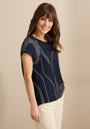 Mörkblå kortärmad t-shirt med vitt abstrakt linjemönster. Mjuk tyg, avslappnad passform, rundad halsringning, lätt sidöppning vid nederkanten.