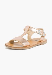 Sandal in rosa gold metallizzato con design a intaglio, cinturino alla caviglia, fibbia regolabile e suola beige. Texture liscia e stile minimalista.