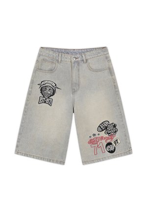 Světle šedé džínové šortky s předním zapínáním na knoflík, kapsami a černo-červenými grafickými nášivkami zobrazujícími lebky, hvězdy a nápis "EST 1971".