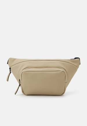 Riñonera beige con un diseño elegante, correa ajustable, compartimento principal y bolsillo frontal, fabricada con un material liso y resistente al agua.