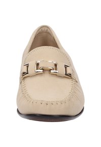 Beige suède instapper met een ronde neus, decoratieve zilveren gesp en gestikte details langs de randen, rustend op een gladde zwarte zool.