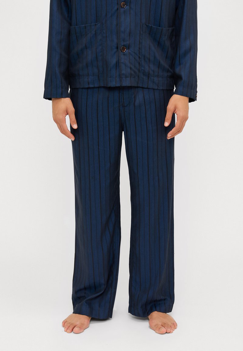 Navy striped pajama set in lightweight fabric, featuring a button-up jacket with two front pockets and matching loose-fitting pants.