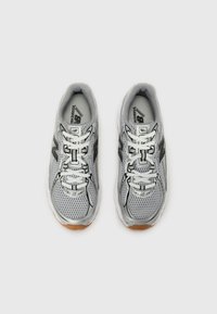 Graue Mesh-Laufschuhe mit schwarzen Akzenten und weißen Schnürsenkeln. Verfügen über eine gepolsterte Sohle und ein gemustertes Material für Atmungsaktivität.