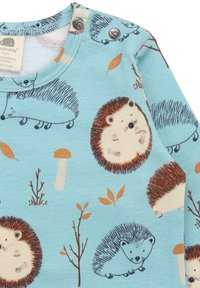 Helles blaues Langarmoberteil mit Illustrationen von braunen und weißen Igeln, Blättern und Pilzen, mit Druckknopfverschlüssen am Hals.