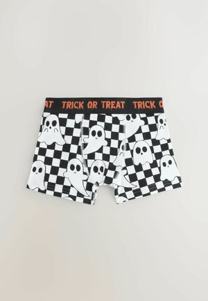 Herrenboxershorts mit einem schwarz-weißen Schachbrettmuster, das Geistergrafiken zeigt. Der elastische Bund trägt die Aufschrift "TRICK OR TREAT" in Orange.
