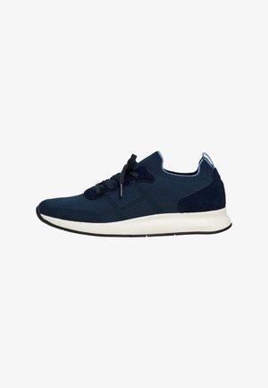 Marineblauwe gebreide sneaker met zwarte veters, witte gevoerde zool en suède hielstuk, ontworpen voor casual of sportief gebruik.