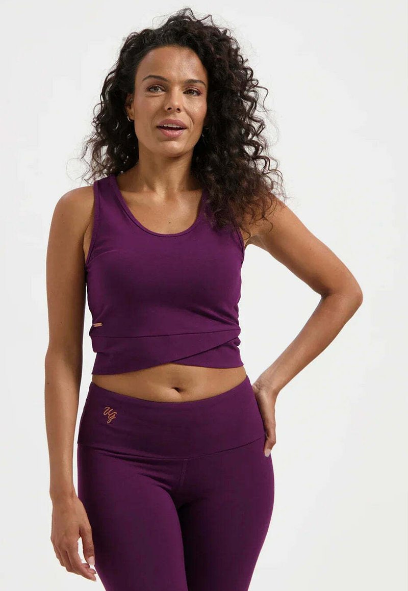 Lila kurzes Tanktop mit rundem Ausschnitt, kombiniert mit hoch taillierten lila Leggings. Beide Kleidungsstücke zeichnen sich durch eine glatte Textur und ein minimalistisches Design aus.