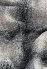 Tessuto a motivo grigio e crema con una texture morbida, che mostra un aspetto intrecciato e leggere variazioni di colore e profondità.