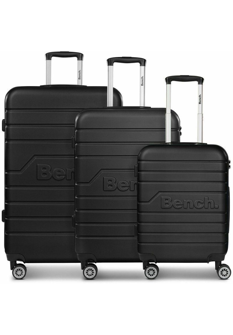 Tre valigie rigide nere di varie dimensioni, caratterizzate da motivi rigati, maniglie telescopiche e quattro ruote girevoli.