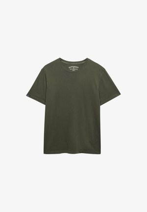 Camiseta de manga corta de algodón lisa color oliva con cuello redondo, con etiqueta pequeña de la marca en la manga y etiqueta impresa dentro del cuello.