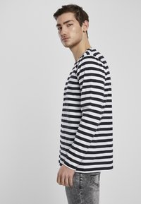 Langarmshirt in zwart-witte horizontale strepen, van katoen, ronde hals, relaxed fit, gecombineerd met lichtgrijze denim.