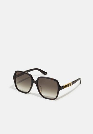 Square sunglasses with a tortoiseshell pattern, gradient gray lenses, black frames, and gold "GUCCI" logo on the temple.