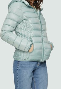 Chaqueta acolchada azul claro con capucha, que presenta secciones acolchadas, puños elásticos y dos bolsillos laterales. Textura de tela lisa y brillante.