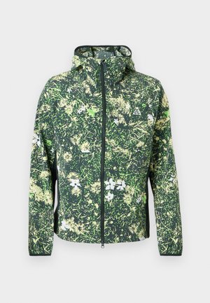 Green hooded jacket with full zipper and abstract floral camouflage pattern in light green, white, and beige tones.