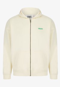 Sudadera con cremallera color crema y capucha, con el logo verde "LEGACY". Fabricada en tela suave, tiene bolsillos frontales y puños de canalé.