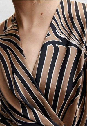 Enveloppez le haut dans un tissu brun et noir avec de larges rayures blanches. Texture lisse avec un décolleté en V profond et un design superposé.