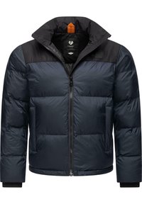 Piepūšamais mētelis tumši zilā krāsā ar melniem pleciem, priekšējais rāvējslēdzis, sānu kabatas, augsts apkaklis un oranžs akcents pie kakla.