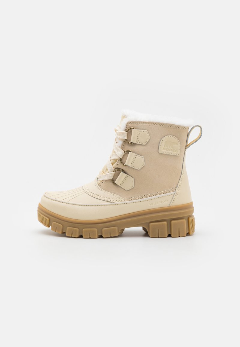 Beige vanntette ankelstøvler med en teksturert gummi såle, tre side-spenner og en myk fleecefôring på toppen. Rund tå-design.