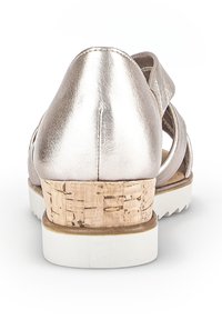 Metalen roségouden schoen met een kurken hak. Heeft een gestructureerd ontwerp, witte zool en een zachte textuur. Open achterkant en zijbanden.