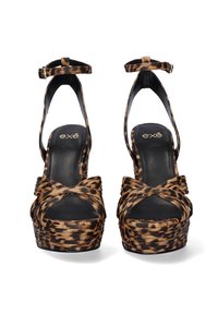 Sandalias de plataforma con estampado de leopardo, con una amplia correa frontal retorcida, correa para el tobillo y tacón alto. Fabricadas en tejido suave con suela negra.