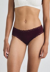 Bordo čipkani hipster donji veš s valovitim rubom, izrađen od mekanog materijala, koji se savršeno prilagođava i nema vidljivih šavova.