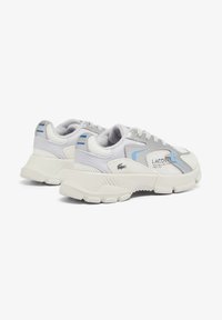 Sneakers Lacoste con tomaia in mesh bianco e materiale sintetico, caratterizzati da accenti blu chiaro e suola testurizzata. Design con lacci e tallone di supporto.