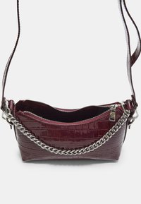 Piccola borsa a spalla in pelle sintetica di colore rosso scuro con texture effetto coccodrillo, dettagli in catena argentata e chiusura con zip, mostrata aperta dall'alto.