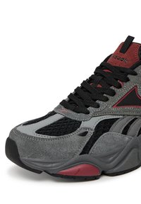 Szare trampki z połączeniem materiałów siateczkowych i zamszowych. Czarne sznurowadła, czerwone akcenty oraz gruba gumowa podeszwa o teksturowanym wzorze.