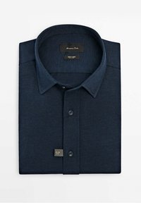 Chemise homme bleu marine foncé slim fit pliée, avec boutons et col classique, en tissu jersey.