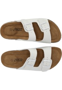 Witte instap sandalen met twee verstelbare banden, kurken inlegzool en lichtbruine gestructureerde voetbed. Heeft een gladde afwerking en zilveren gespen.