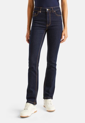 Jean en denim bleu foncé avec des coutures orange, coupe droite, cinq poches, fermeture par bouton et zipper, et taille mi-haute.