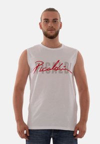 White sleeveless shirt featuring a large logo in red script and gray block letters. Made of cotton with a smooth texture.