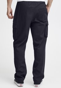 Pantaloni cargo negri din bumbac, cu talie elastică, având buzunare laterale și un buzunar pe spate, expuși din spate.