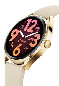 Orologio smart rotondo con cassa dorata e cinturino in silicone beige chiaro. Il display mostra numeri audaci in rosa e arancione su uno sfondo scuro.