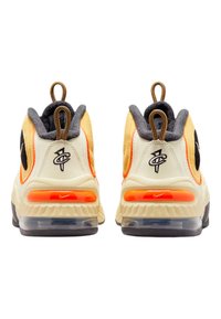 Adidași Nike cu un uppers crem, accente gri, amortizare portocalie la călcâi și un logo negru. Prezintă o talpă texturată și bucle pentru prindere.