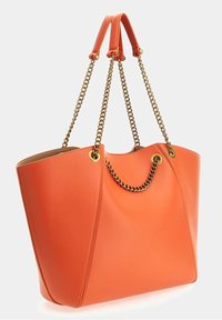 Bolso tote de cuero naranja con dos asas superiores y un detalle de cadena dorada. Presenta una forma estructurada y detalles de costuras visibles.