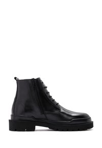 Botas de tobillo de cuero negro que presentan una combinación de cordones y cremallera lateral, una suela gruesa con tracción y un acabado liso y brillante.